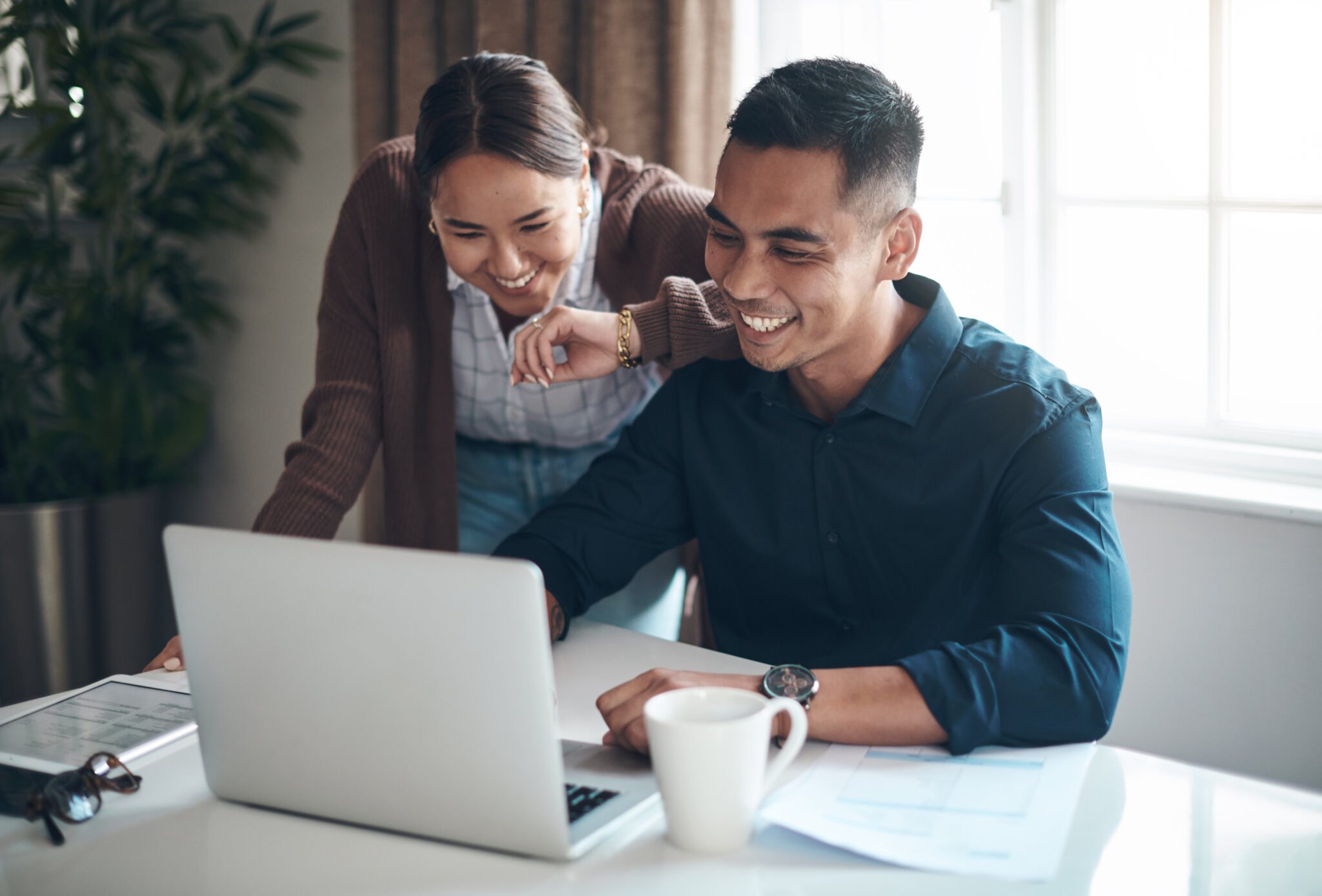 Happy with how their finances are looking. Shot of a young couple using a laptop together at home.